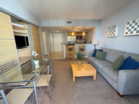 Bright living room with balcony access and city views.