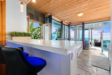 A bar peninsula that brings the outside in. With glass walls and doors opening to the ocean, this space is flooded with light, creating a bright and airy atmosphere perfect for enjoying cocktails or simply soaking in the views.