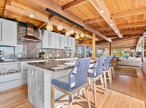 Where modern design meets coastal charm—this contemporary kitchen features a spacious island and sleek bar seating, perfect for cooking, entertaining, and enjoying ocean-inspired living