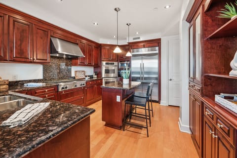 Chef’s kitchen with rich wood cabinetry and granite counters