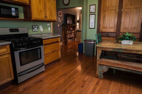 The kitchen features a gas stove / oven and bench seating around a large table