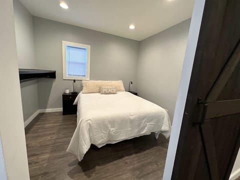 (BEDROOM) A soothing queen-sized bed awaits, complete with stylish nightstands on either side for added comfort and style. 