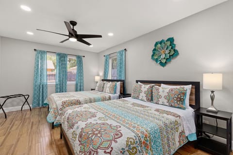 Relax and unwind in our spacious bedroom, featuring two comfortable queen-sized beds and a TV for your entertainment and relaxation