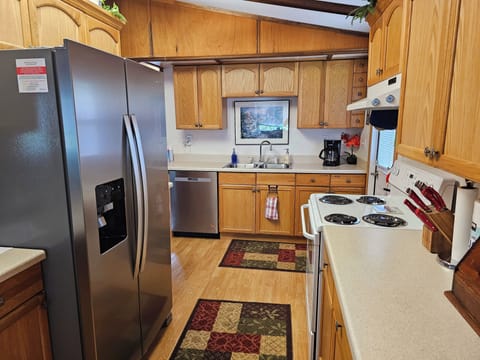 New refrigerator and dishwasher.  View from the dining room into the kitchen.