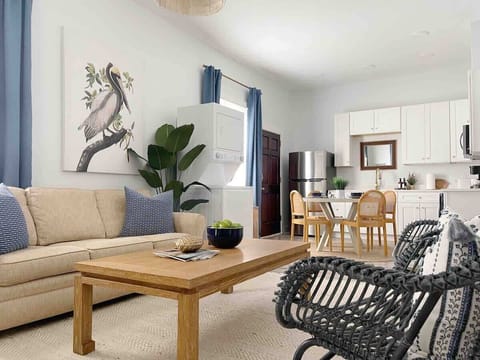 A comfortable living room featuring a long, cozy couch as well as additional seating, creating a cozy and inviting space for reading, watching TV, relaxing and chatting. 