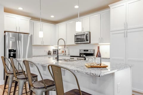 Our kitchen boasts a large island for entertaining. Stainless steel appliances, and granite countertops.