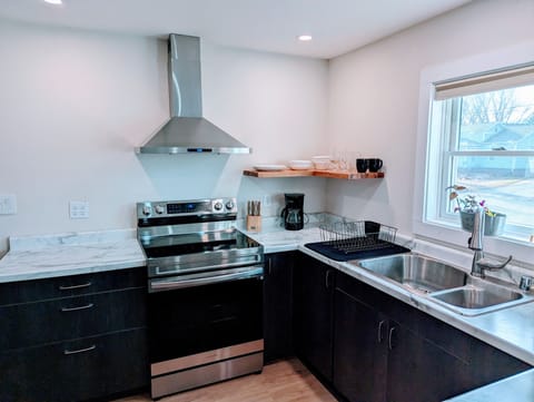 Modern kitchen including full size stove, hood vent and garbage disposal.