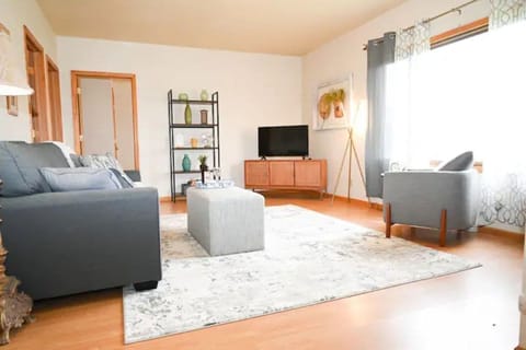 Relax in the living room with a luxurious rug and beautiful natural lighting.