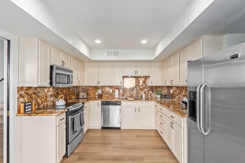 Beautiful kitchen with stainless steel appliances and cooking essentials. 