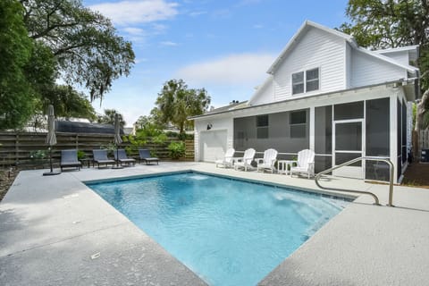 Private Heated Pool at Blue Heron Cottage – St. Simons Vacation - Your own slice of St. Simons sunshine—this private heated pool features in-water umbrellas, a fully fenced yard, and plenty of seating for afternoon hangs or evening swims. Perfect for families or anyone chasing a no-drama vacation.