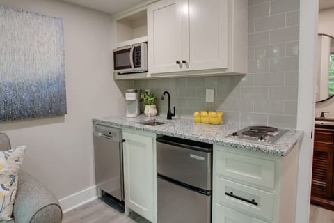 The kitchenette is equipped with a stovetop, microwave, tea and coffee station, sink, dishwasher, and mini refrigerator.