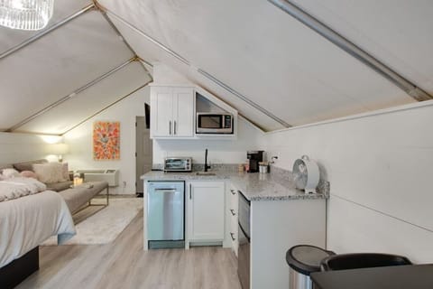 Spacious glamping tent with a complete kitchenette including a dishwasher and modern appliances, paired with a tasteful decor for a unique and enjoyable getaway