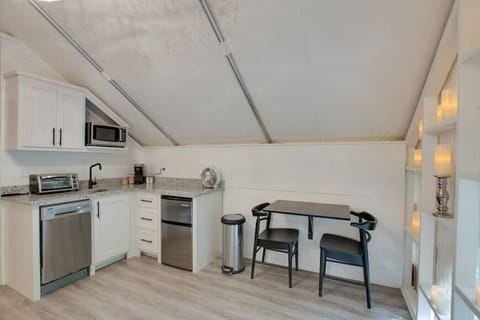 Spacious glamping tent featuring a complete kitchenette with modern appliances and tasteful décor,perfect for a comfortable and entertaining retreat