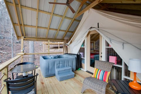 Spacious glamping tent featuring a private hot tub, king bed, and scenic views. Experience luxury camping in the heart of North Alabama.