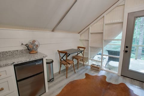 Glamping tent with a tasteful and fun décor, dining space for a meal in, perfect for fun-filled evenings and relaxation in nature.