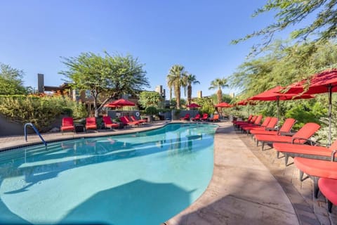 Stretch out on red loungers beside shimmering blue water.