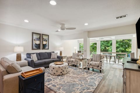 Bright and Cheerful Living Area with Sofa and Loveseat Centered Around a Flat Screen Smart TV