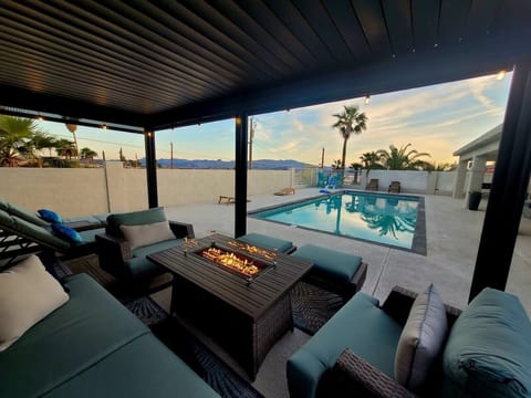 Sink into your own private resort — fire table glowing, pool shimmering, mountains painted on the horizon. This is the backyard you'll never want to leave.