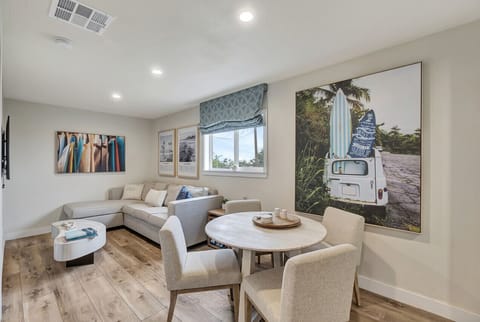 Bright living area w/ cozy sofa & round dining table, perfect for relaxed meals & conversation