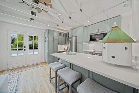 Modern updated kitchen featuring sleek stainless steel appliances, a spacious layout, and a stylish kitchen island with barstool dining—perfect for meals and gathering.