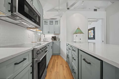 Modern updated kitchen featuring sleek stainless steel appliances, a spacious layout, and a stylish kitchen island with barstool dining—perfect for meals and gathering.