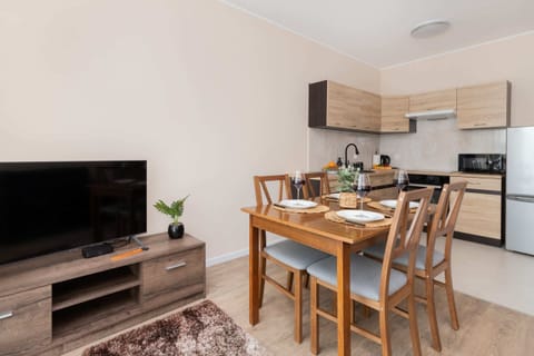 A view of the living area featuring a modern TV unit, a flat-screen TV, and access to the balcony.