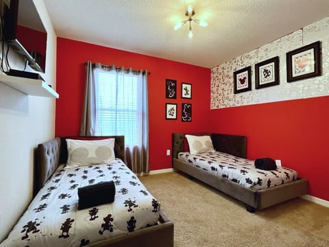 Relax in the Disney Themed bedroom featuring two comfortable twin beds, a flat-screen TV, high-speed Wi-Fi, and plenty of space to unwind.