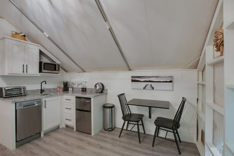 Glamping tent featuring a fully stocked kitchenette with a dishwasher, coffee maker, and more  for added fun and relaxation.