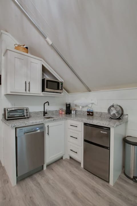 Spacious glamping tent featuring a complete kitchenette with modern appliances and tasteful décor,perfect for a comfortable and entertaining retreat