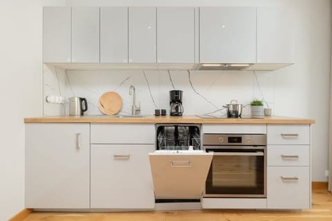 A closer view of the minimalist kitchen design, highlighting the clean white cabinetry and cooking area.