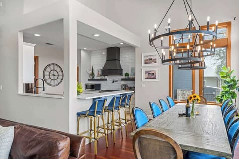 Where culinary delights meet shared moments: Our expansive 10-person dining table seamlessly opens to the kitchen, creating the perfect setting for gatherings filled with delicious food and heartwarming conversations.