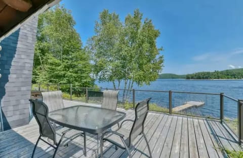 Lakeside patio dining area with glass railing and peaceful views