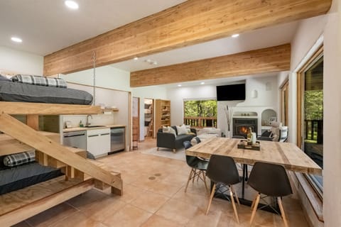The lower level living space serves as a studio with dining table, kitchenette, living area, fireplace, and full over full bunk beds - all with amazing views