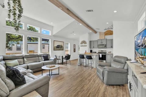 The inviting living area boasts a plush sectional sofa and a recliner, providing ample seating for relaxation and leisurely evenings.