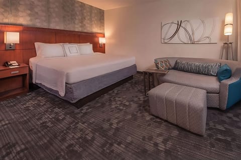 Unwind in a spacious room with plush bed and sofa.
