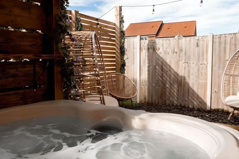 Soak up relaxation in a private hot tub, enveloped by rustic wood paneling and soft, ambient lighting.Soak up relaxation in a private hot tub, enveloped by rustic wood paneling and soft, ambient lighting.