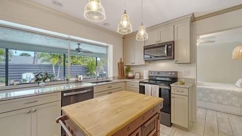 Prepare delicious meals with a view! Our kitchen features multiple outdoor windows overlooking the inviting pool area. Cooking never felt this refreshing. 🍳🌴 #PoolsideCooking #KitchenViews 🏊♂️🍽️