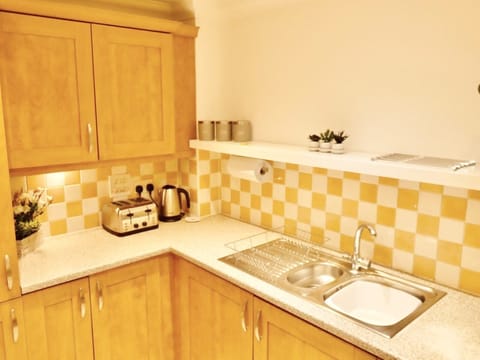 In the kitchen, a countertop holds the sink, cabinets for storage and kitchen basics