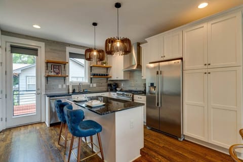 Gather in the kitchen around the island, featuring comfortable seating for two perfect for coffee, meals, or conversation.