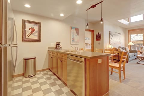 Step into your fully equipped kitchen where warm wood cabinets and stainless steel appliances create the perfect space for preparing mountain meals. Natural light flows through skylights as you cook, with cozy dining just steps away.