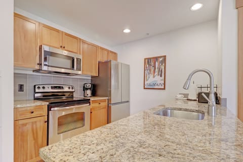 Step into your fully-equipped kitchen where granite countertops gleam under recessed lighting. You'll love preparing meals with stainless steel appliances and warm wood cabinetry.