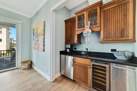 Cozy kitchenette featuring a small fridge, built-in wine cooler, and convenient ice maker—perfect for storing drinks, snacks, and entertaining essentials just steps from the beach.
