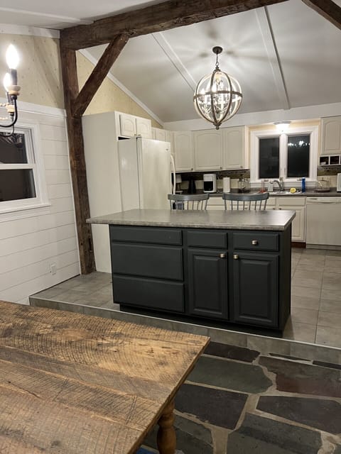 Dining table that comfortably seats 6-8 looking into the kitchen.