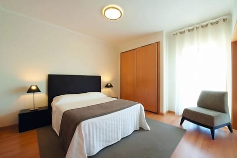 Settle into a spacious bedroom with lounge chair and storage.