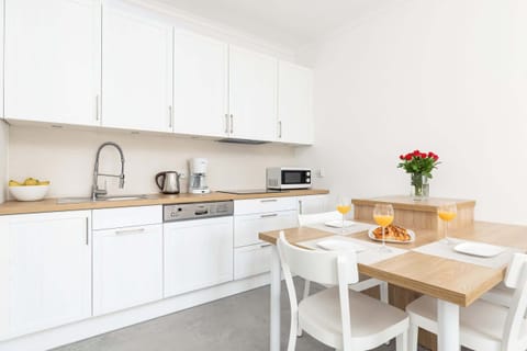 Kitchenette and dining area with table and tableware.