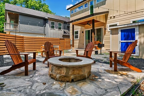 Backyard with fire pit (wood burning), dining space, and cornhole game