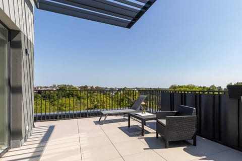 Furnished balcony with green surroundings. 