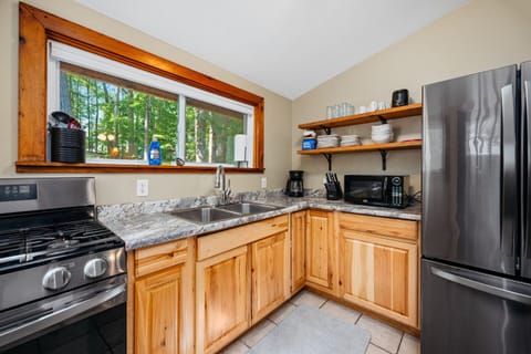 Cook up your favorite meals in a modern, nature-inspired kitchen featuring scenic views and stylish, high-end appliances—where function meets beauty!