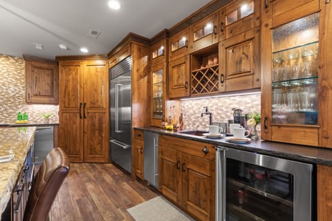 Whip up a meal in this fully-equipped kitchen, featuring a large island with bar seating, granite countertops, and modern amenities.