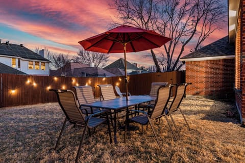 Unwind outdoors in the private backyard with fireplace and dining area—perfect for long-term stays, insurance housing, and relaxing evenings near Frisco attractions.